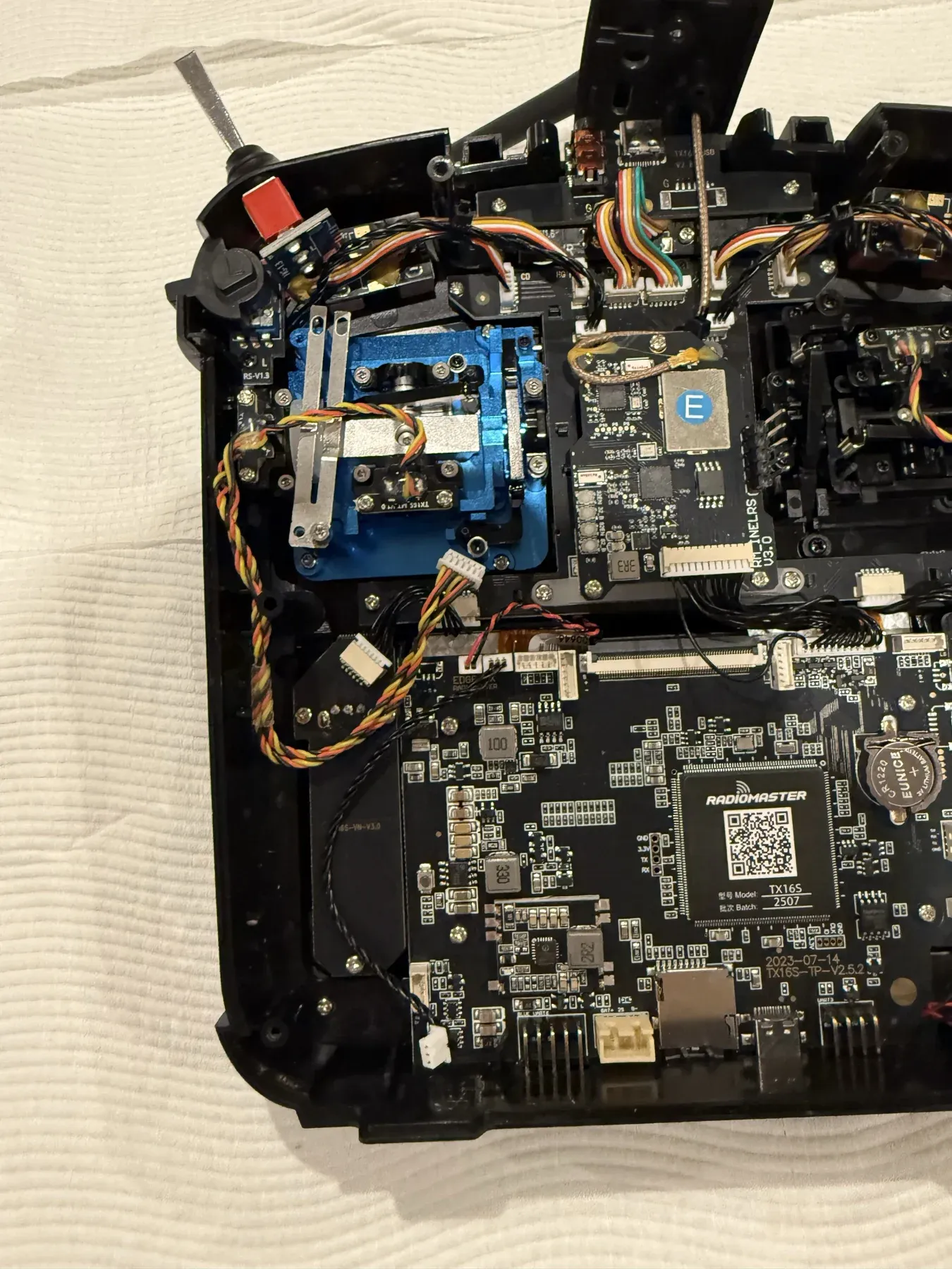 The back of the TX16S opened up, showing its circuit boards, wiring and the new joystick gimbals installed.