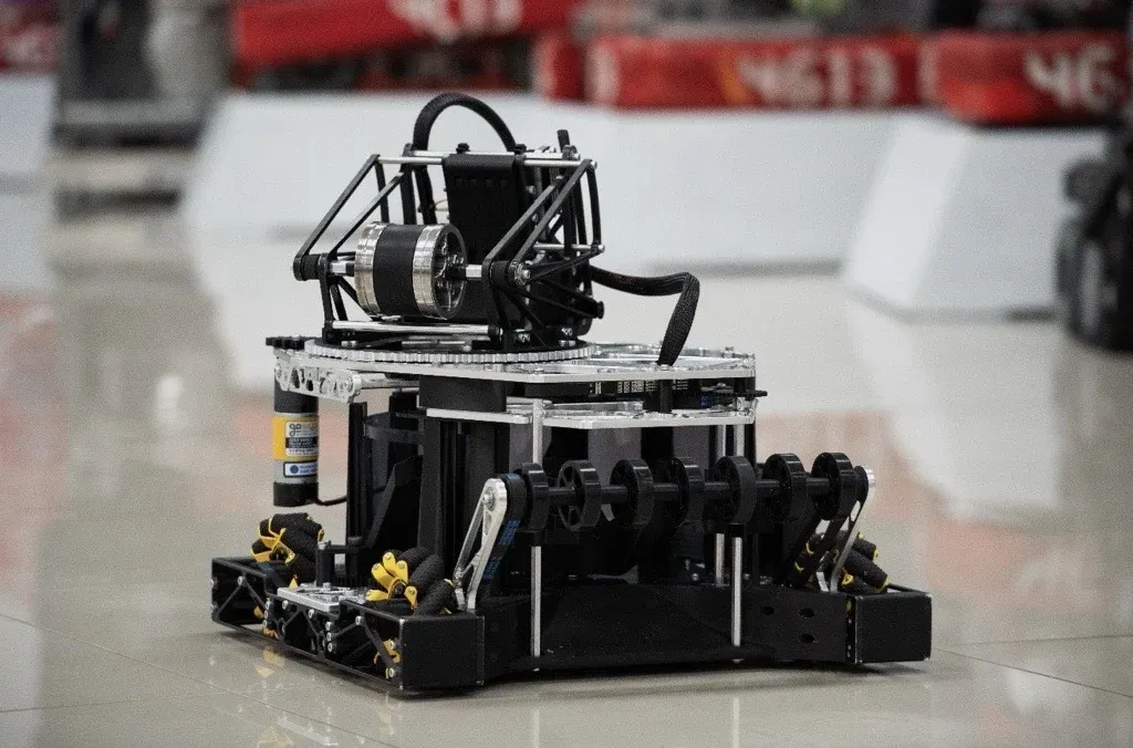 The black FTC robot on mecanum wheels, with its launcher on top, in front of red 4613 banners.